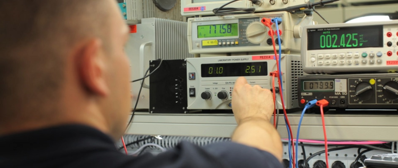 Engineer using laboratory measurement equipment to verify reliability of wide bandgap semiconductor power systems in critical applications